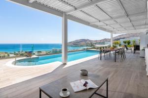 Sala de estar con mesa y vistas al océano en Villa Kastro, en vlicha