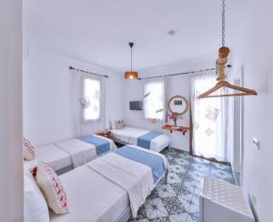 a room with four beds and a table at Dantel Pansiyon Kaş in Kaş