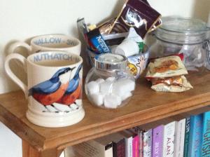a wooden shelf with two coffee cups and other items on it at Gunville House B&B in Grateley