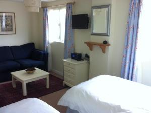 a bedroom with a bed and a couch and a table at Gunville House B&B in Grateley