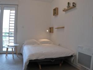 a bedroom with a bed and a table and a window at Studio Cosy Chambray-Les-Tours in Chambray-lès-Tours