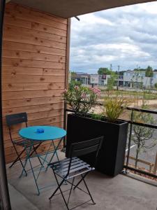 d'une terrasse avec une table bleue et des chaises sur un balcon. dans l'établissement Studio Cosy Chambray-Les-Tours, à Chambray-lès-Tours