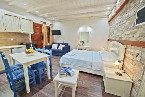 a bedroom with a bed and a kitchen with a table at Flamingo Hotel Pelion - Seaside Superior Studios & Suites in Chorefto