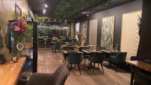 uma sala de jantar com mesas, cadeiras e flores em Boutique Hotel Ravioli Brothers em Haia