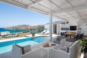 a villa with a swimming pool and a living room at Villa Faros in vlicha