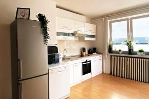 a kitchen with white cabinets and a refrigerator at 3 room apartment in Lengerich in Lengerich
