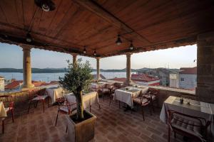 a restaurant with tables and chairs and a view of the water at V Apartment Šibenik in Šibenik