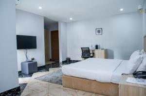 Habitación de hotel con cama y TV en Orange Roof Lodge, en Abuja