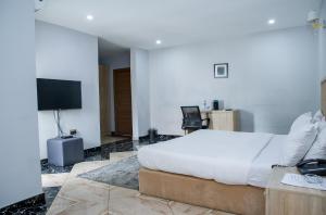 une chambre d'hôtel avec un lit et une télévision dans l'établissement Orange Roof Lodge, à Abuja