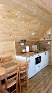 a kitchen with a table and a wooden ceiling at Brvnara Miris Bora in Šljivovica