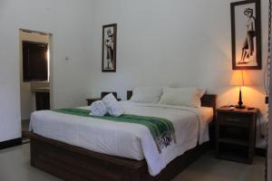 a bedroom with a large bed with two towels on it at Kubu Nusa in Nusa Lembongan