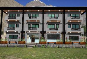 a large white building with plants in front of it at Eat and Read Hotel in Skardu