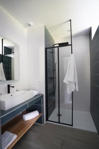 y baño con ducha acristalada y lavamanos. en Hôtel Les Vignes, en Chassiers