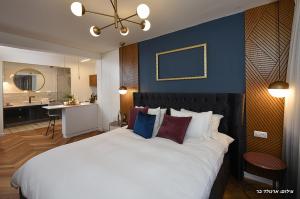 1 dormitorio con 1 cama blanca grande y baño en מוריה גולד - MORIA GOLD, en Manot