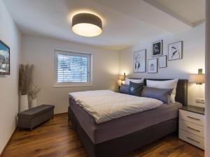 a bedroom with a large bed and a window at Sonnberg Living Superior Plus in Brixen im Thale
