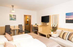 a hotel room with a bed and a living room at QU Hotel Augsburg in Augsburg