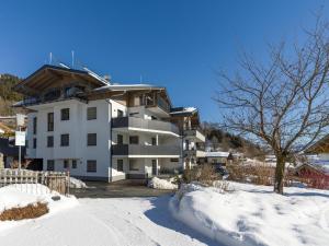 a large white building in the snow at Sonnberg Living Superior Plus in Brixen im Thale