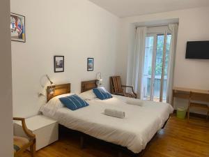 a bedroom with a large bed with blue pillows at Olatu Guest House HT LSS00253 in San Sebasti&aacute;n
