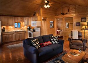 sala de estar con sofá y cocina en Reclusive Moose Cabins, en West Glacier