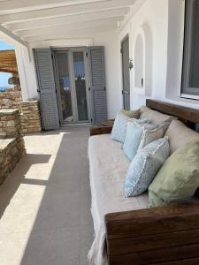 a couch sitting on a porch with pillows on it at Sorokos Villa Panagia beach in Andiparos
