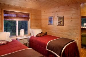 a bedroom with two beds in a log cabin at Reclusive Moose Cabins in West Glacier