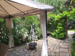 a patio with an umbrella and a swing at Fitness - domek z ogródkiem in Stegna