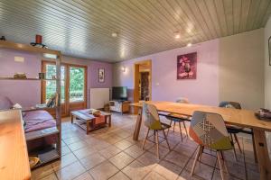 sala de estar con mesa de madera y sillas en Chene Rouge, en Lapoutroie