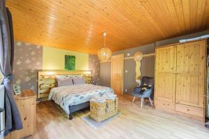 1 dormitorio con cama y techo de madera en Chene Rouge, en Lapoutroie