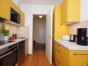 eine Küche mit gelben Schränken und einer Arbeitsplatte in der Unterkunft Kaiservillen Heringsdorf - Ferienwohnung mit 1 Schlafzimmer und Balkon D134 in Heringsdorf