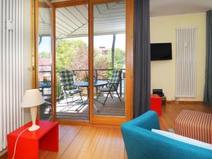 ein Wohnzimmer mit einem blauen Sofa und einem Tisch in der Unterkunft Kaiservillen Heringsdorf - Ferienwohnung mit 1 Schlafzimmer und Balkon D134 in Heringsdorf