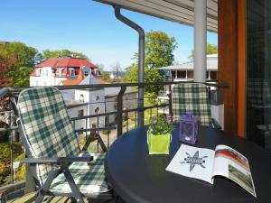 einen Tisch und Stühle auf einem Balkon mit einem Boot in der Unterkunft Kaiservillen Heringsdorf - Ferienwohnung mit 1 Schlafzimmer und Balkon D134 in Heringsdorf