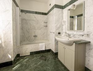 y baño con lavabo, bañera y ducha. en Hotel Il Gelso en Pontevico