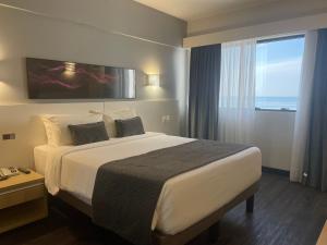 um quarto de hotel com uma cama grande e uma janela em Mercure Camboriu no Balneário Camboriú