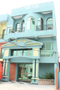 a blue building with windows and a balcony at RESIDENCE PALAIS DU STADE in Cotonou