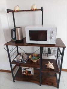 MontecalvoliにあるB&B RossoArancioの棚の上に電子レンジがあり、その上に食べ物が置かれている