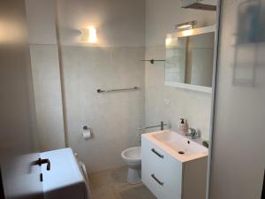 ein weißes Bad mit einem Waschbecken und einem WC in der Unterkunft La Quiete 56 Lake view Apartment by Gardadomusmea in Tremosine sul Garda