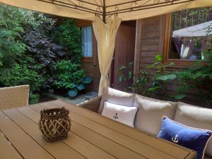 drewniany stół z poduszkami na patio w obiekcie Fitness - domek z ogródkiem w Stegnie