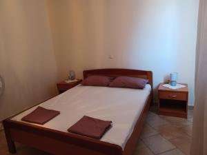 a bedroom with a large bed with two night stands at Apartments Ivić in Rab