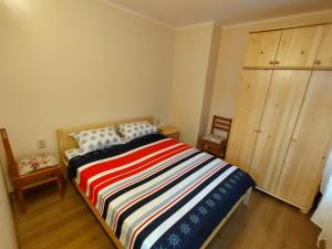 a bedroom with a bed with a colorful striped blanket at Apartment RELAX in Tsarevo in Tsarevo