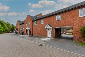 a brick building with a garage on a street at Modern 2-BR Home WiFi plus Parking in Thringstone