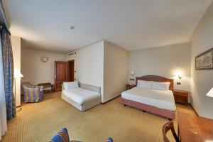 um quarto de hotel com duas camas e uma mesa em Relais Santo Stefano em Sandigliano