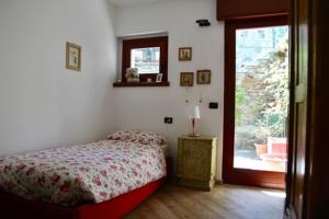 - une chambre avec un lit et une porte coulissante en verre dans l'établissement Appartamento Castel, à Chiesa in Valmalenco