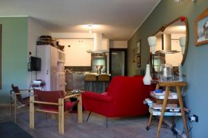 - un salon avec un canapé rouge et un fauteuil rouge dans l'établissement Appartamento Castel, à Chiesa in Valmalenco