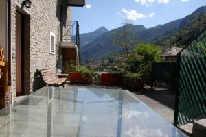 - un balcon en verre avec une chaise au-dessus d'une maison dans l'établissement Appartamento Castel, à Chiesa in Valmalenco