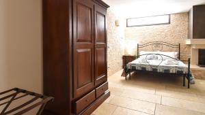 1 dormitorio con 1 cama y un gran armario de madera en Casa Carlà by Rentbeat, en Surbo