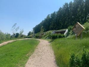 a dirt road next to a grassy field at Zeeuwse Dijksuite in Kortgene