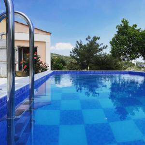a large blue swimming pool with a house at Irene Villa in Psinthos