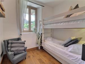 a bedroom with two bunk beds and a chair at Appartement Morzine, 5 pièces, 8 personnes - FR-1-627-22 in Morzine