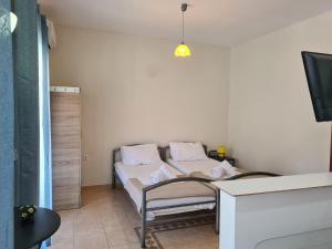 a small room with a bed and a tv at Frodo Studios in Kavos