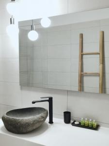 ein Badezimmer mit einem Steinwaschbecken und einem Wasserhahn in der Unterkunft Gardenia in Stavros